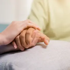 Zwei Hände halten sich fest. Eine jüngere Hand stützt eine ältere, was Hoffnung und Unterstützung für COPD Pflegegrad symbolisiert.